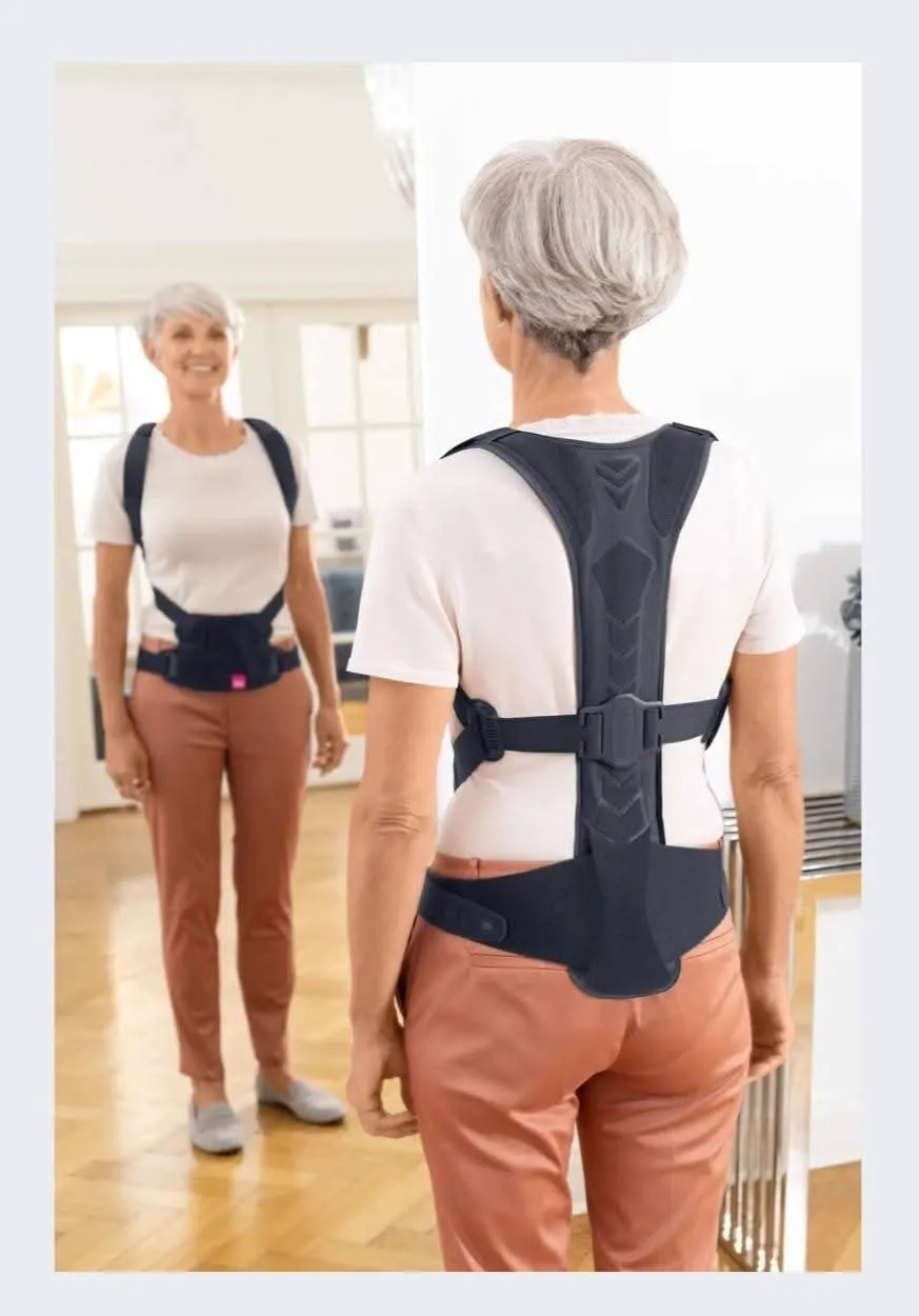 Mujer frente al espejo con el corrector postural de espalda puesto